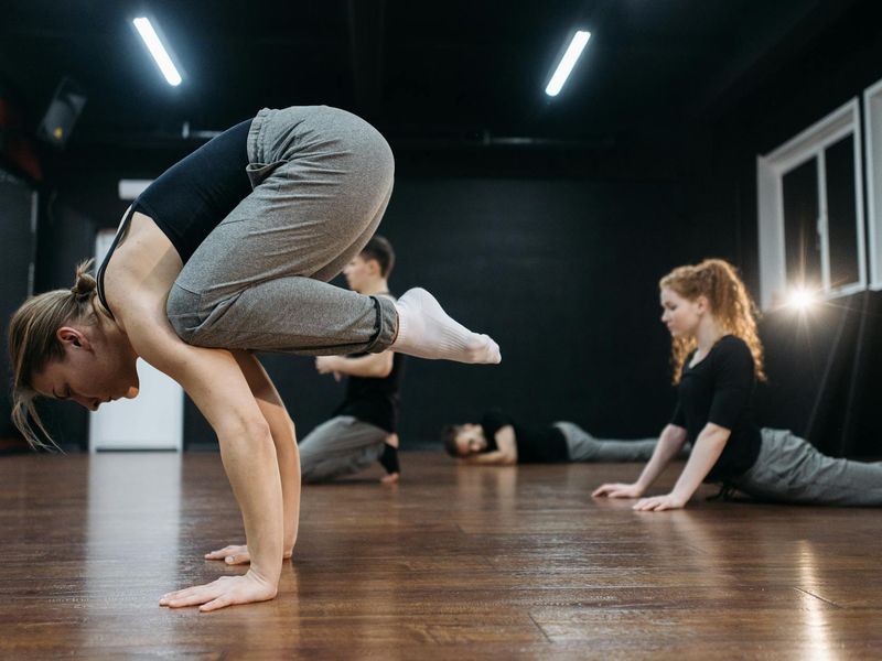 Person performing a calm, controlled yoga movement indoors.